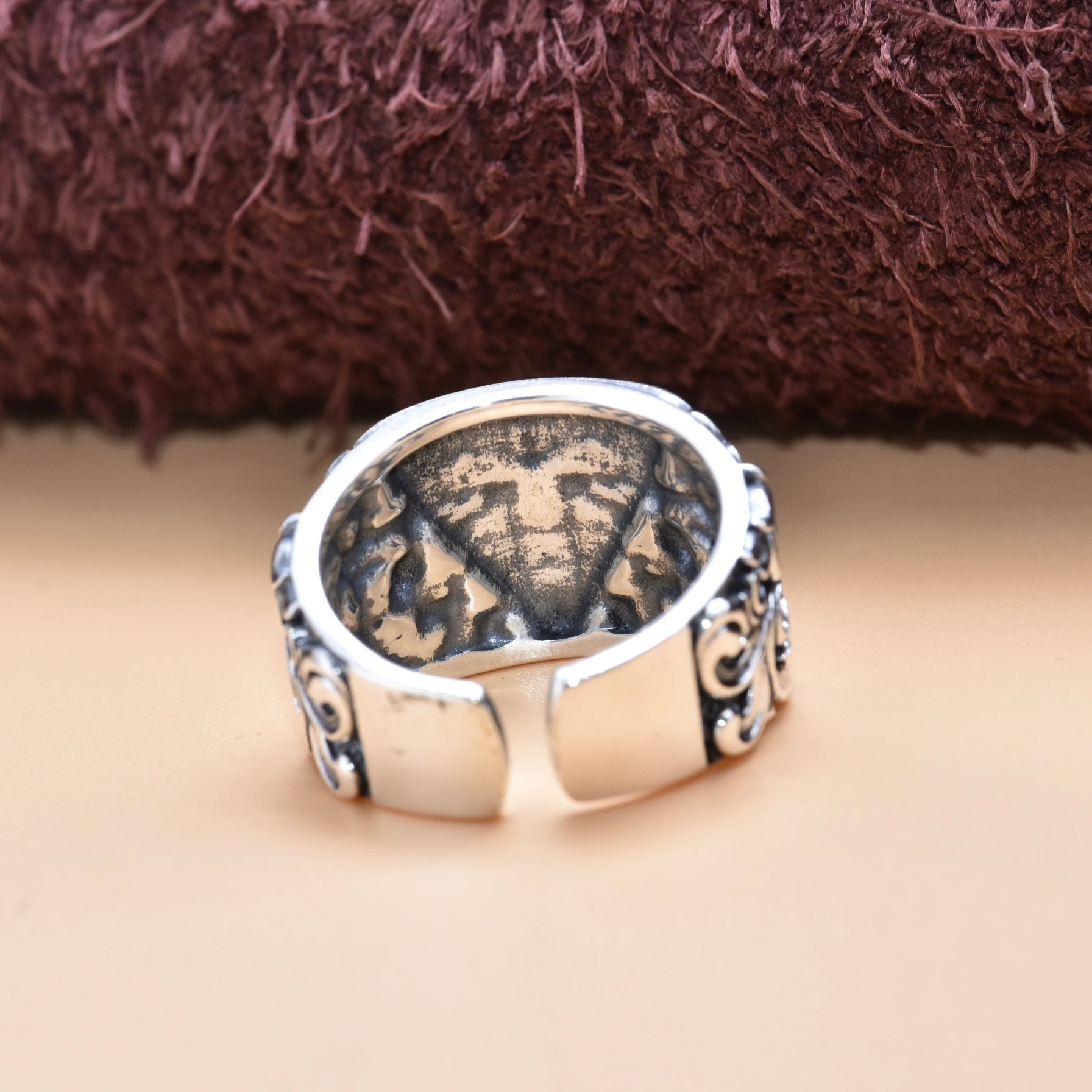 Adjustable silver ring displaying detailed artistry and a polished finish.